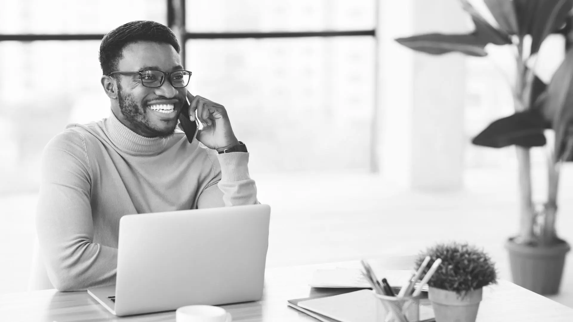 A man sitting at his desk on the phone