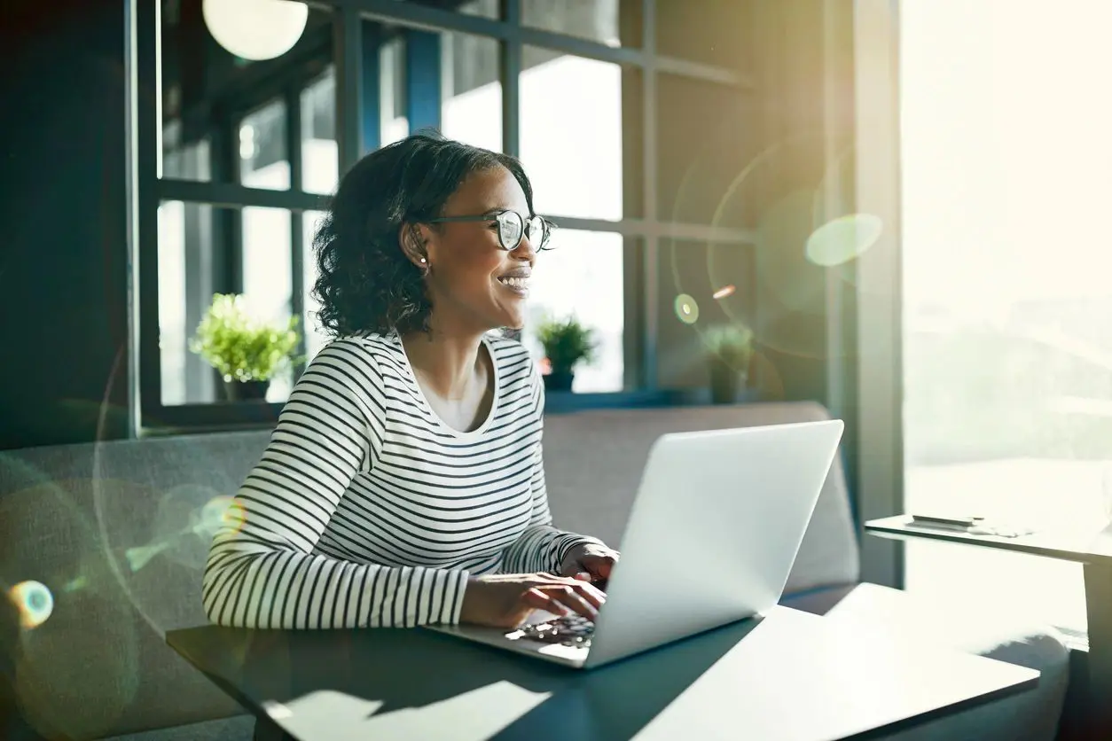 A woman sitting at a table with a laptop.