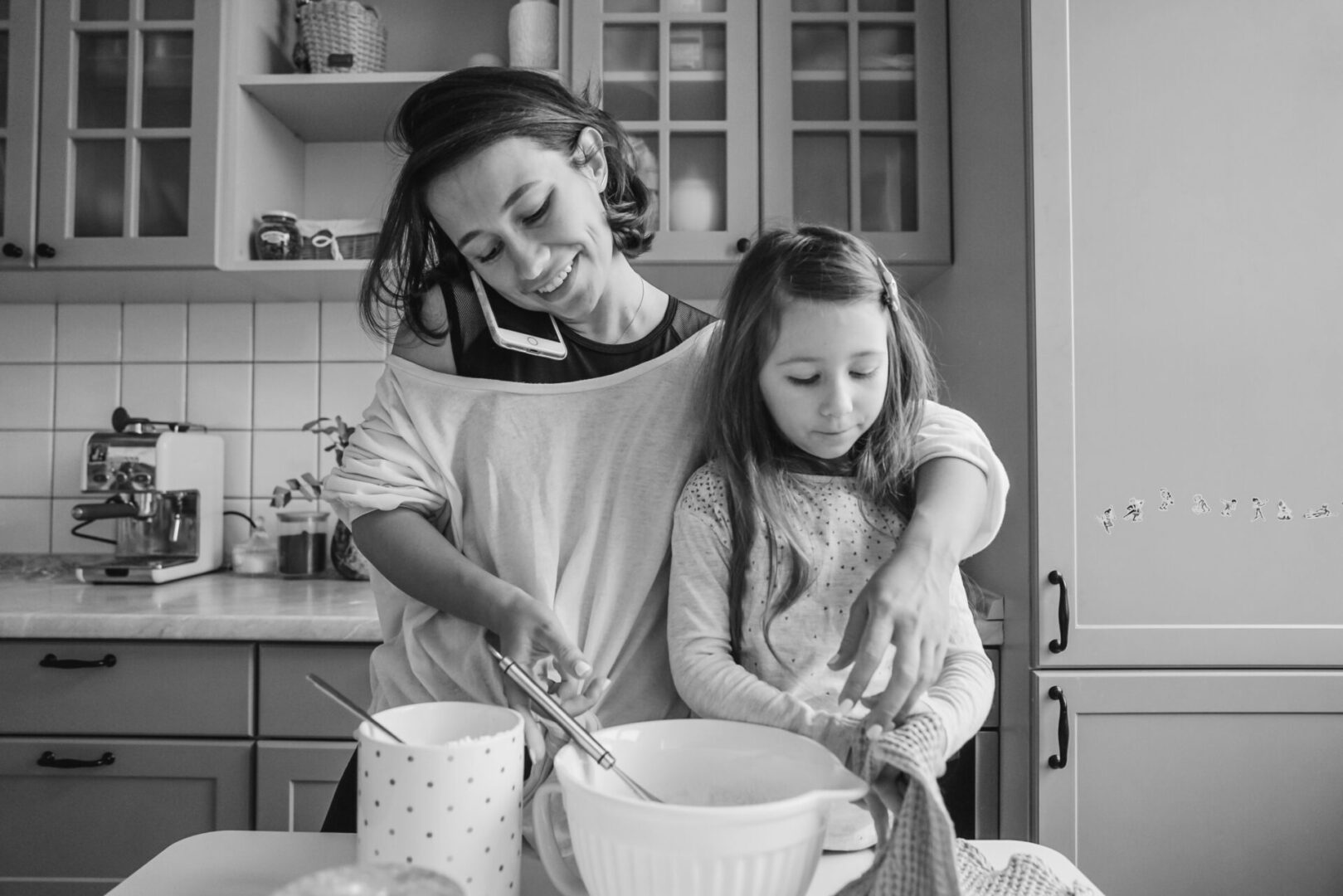 A woman and girl in the kitchen preparing food.