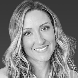 A black and white photo of a woman smiling.