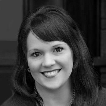 A black and white photo of a woman smiling.